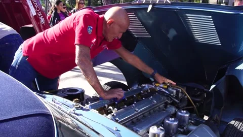 Owner checking the engine of British convertible sports car 1964 Jaguar E-Type. Stock Footage 322134574