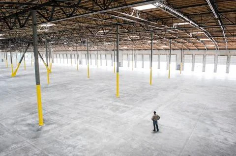 Owner checking out the new interior of a large empty warehouse space. Stockfoto's