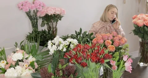 Owner Of Flower Studio In The Background Is Ordering Flowers With Mobile Phone. Stock Footage 124550102