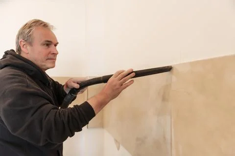 The owner of the house removes construction dust with a vacuum cleaner. Do It 스톡 사진