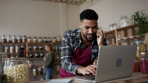 Owner preparing an online order on laptop in zero waste shop. Stock Footage 153943682
