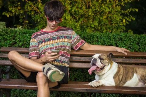 Owner using tablet device sitting with bulldog. Foto stock