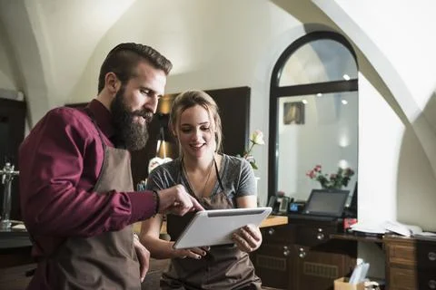 Owners discussing using tablet at restaurant Stock Photos