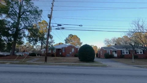 Ows of urban duplex homes on Lumpkin road passing traffic clear blue sky Stock Footage 152170537