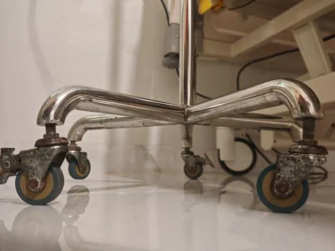 Oxidized chrome, rust, and blue caster wheels on medical stand base Photos