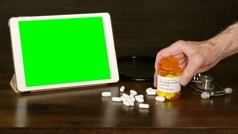 Oxycodone opiate tablets being spilled onto a doctor's table with a green screen Stock-Footage 73515469