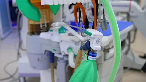 Oxygen breathing mask, ambu bag and diverse tubes connected to modern lung venti Stock Footage 235486414