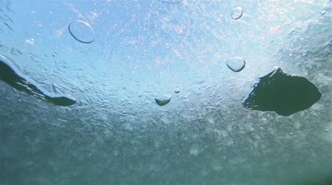 Oxygen bubbles move effectively under the ice of a frozen lake in slow motion Stock Footage 59737066