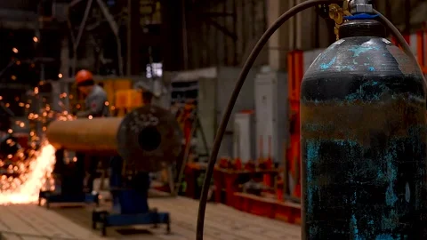 Oxygen cylinder with welder working in background. Stock Footage 341790016