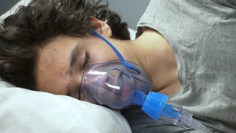 Oxygen mask on the face of a guy lying on a bed in a hospital Stock-Footage 145416792