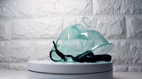 Oxygen mask rotating on a white surface, showcasing its design and functional Stock Footage 297151891