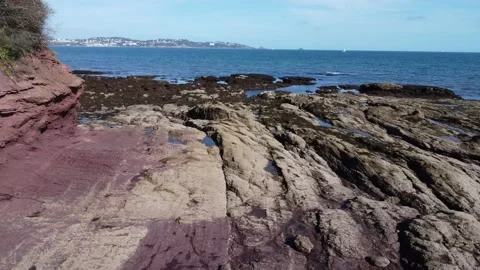 Oyster Cove, Torbay, Devon, England: Drone View: Isolated man &amp; rock formations Stock Footage 218858875