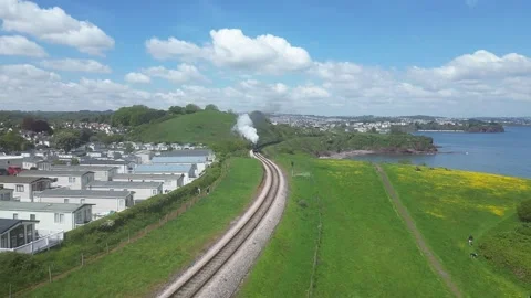 Oyster Cove, Torbay, S. Devon, England: DRONE VIEW: Slow motion of steam train Stock Footage 241140616