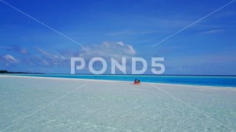 P02518 Aerial flying drone view of Maldives white sandy beach 2 people young Stock Photos