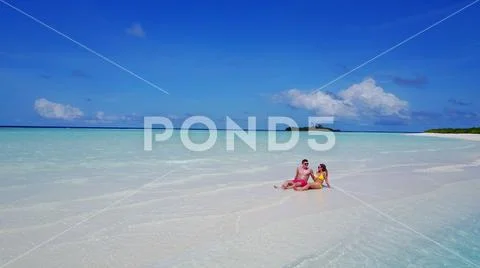 P02557 Aerial flying drone view of Maldives white sandy beach 2 people a young Stock Photos