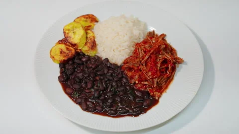 Pabellon criollo serving shredded beef, black beans, white rice, and fried Stock Footage 346337560