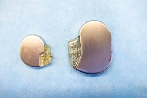Pacemaker and an implantable defibrillator lying on a light blue base Stock Photos
