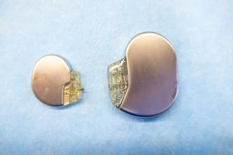 A pacemaker and an implantable defibrillator lying on a light blue base Stock Photos