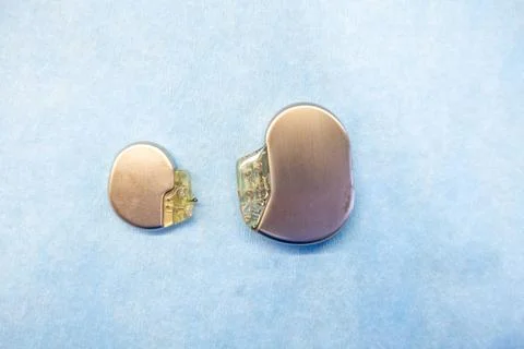A pacemaker and an implantable defibrillator lying on a light blue base Stock Photos