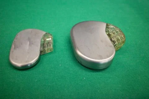 Pacemaker lies directly next to a defibrillator on a green surgical drape 스톡 사진