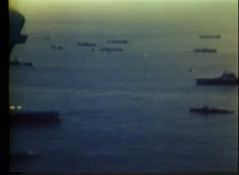 PACIFIC - 1943: Fleet anchorage - A flat-top sits ringed by moored hulls 库存影片 343931692