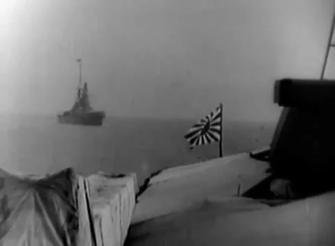 PACIFIC - 1944: Fleet observation - Rising-sun ensign frames hazy warship Stock Footage 344508048