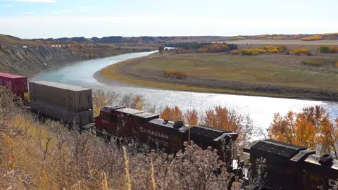Pacific Atlantic Railway Train crosses a field in Alberta Stock Footage 197052282
