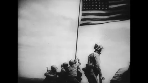PACIFIC - CIRCA 1945: American troops raise the Stars and Stripes Stock Footage 339065375