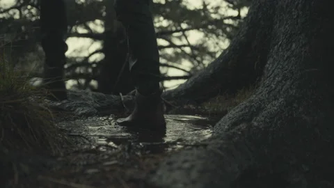 Pacific Coast boots walking through a puddle on a stormy day Stock Footage 230301018