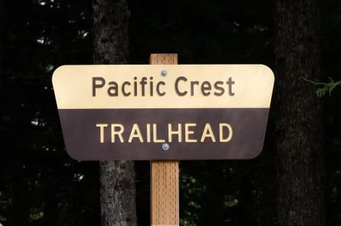 Pacific crest trail sign on post with dark background Stock Photos