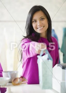 Pacific Islander Female Sales Clerk Handing Gift Bag