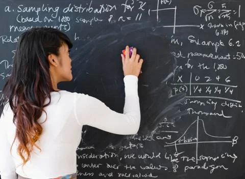 Pacific Islander teacher erasing math from blackboard Stock Photos