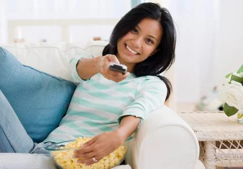 Pacific Islander woman pointing remote control Stock Photos