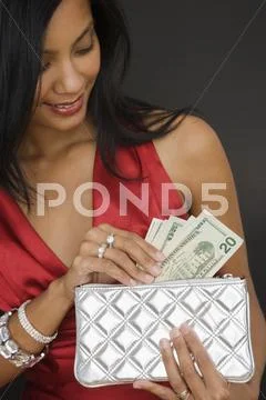Pacific Islander woman putting money in purse Stock-Fotos