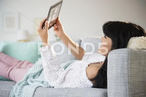 Pacific Islander Woman Using Digital Tablet On Sofa