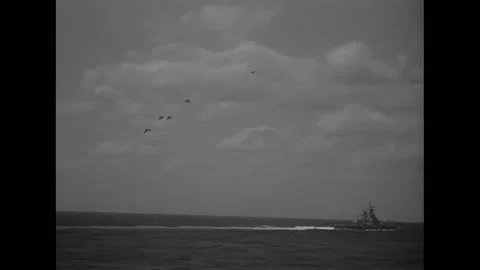 PACIFIC OCEAN - 1942 - Flak bursts in the sky with a battleship in the Stock Footage 312793716