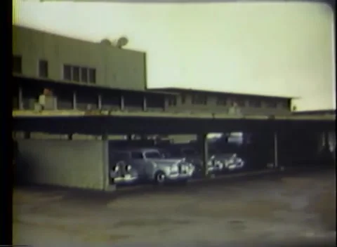 PACIFIC OCEAN - 1945: Base parking — 1940s cars parked under a long canopy 库存影片 343120253