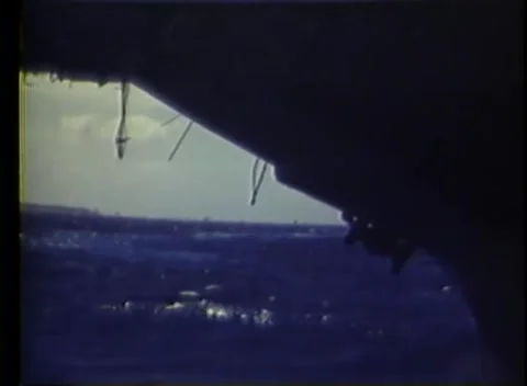 PACIFIC OCEAN - 1945: Carrier bow — anchor hangs at a silhouetted bow 库存影片 343119744
