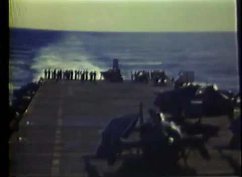 PACIFIC OCEAN - 1945: Flight deck — crew line the deck edge in gun smoke Stock Footage 343120202