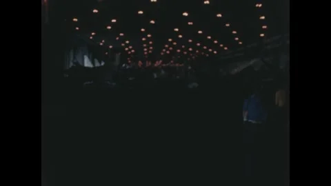 Pacific Ocean 1960s: Rows of glowing red and white lights hang overhead in a Stock Footage 344071949
