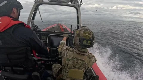 PACIFIC OCEAN - 4.17.2025 - US Coast Guardsmen board a drug smuggling boat and Stock Footage 312692785