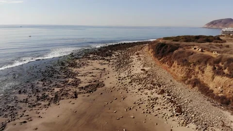 Pacific Ocean Beach, Rocks, Cliff, Aerial Tilt Up Shot Stock Footage 146156022
