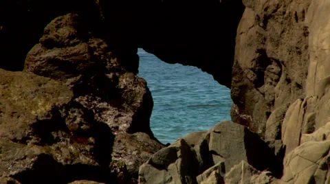 Pacific Ocean seen through a hole in a rock Stock Footage 36571852