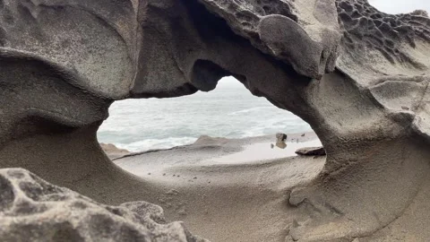 The Pacific Ocean through a small hidden arch on the Oregon Coast Stock Footage 329448801