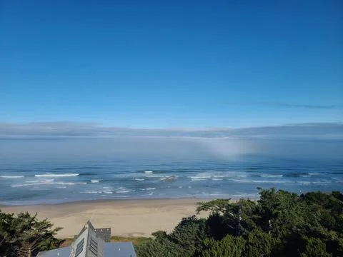 Pacific Ocean Waves and Sandy Oregon Coast Beach Under Wide Blue Sky Stock Photos