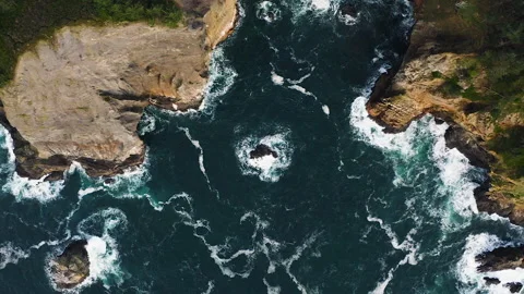 Pacific Ocean waves breaking against Oregon Coast cliffs. Top down zoom Stock Footage 268802231