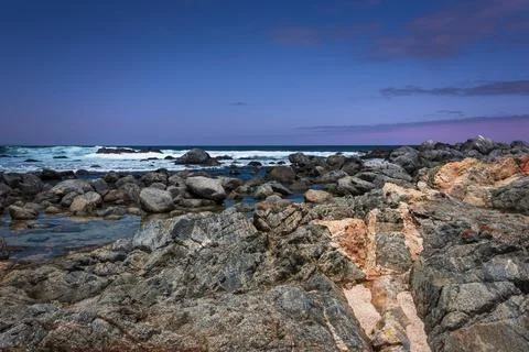 Pacific Ocean waves in central Chile with rocks and pink clouds Stock Photos
