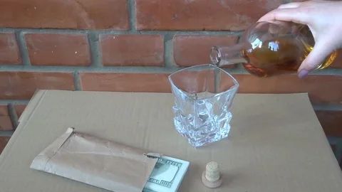 Pack of 100 dollar bills and whiskey in female hand Stock Footage 97786317