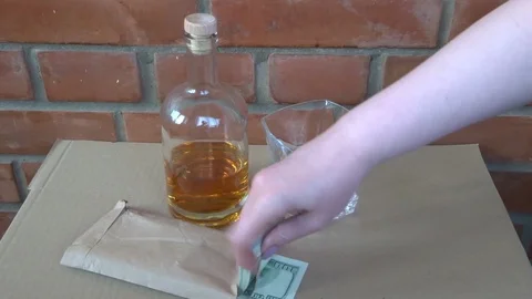 Pack of 100 dollar bills and whiskey in female hand Stock Footage 97786360