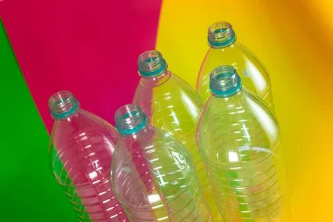 A pack of 5 empty and recyclable water bottles, with no caps, on a colored vi Stock Photos
